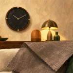 Pendule murale vintage noire sur mur beige dans un salon cosy